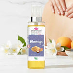 L'huile de massage Emma Noel. Des fleurs blanches sont plaçés à l'arrière du produit.