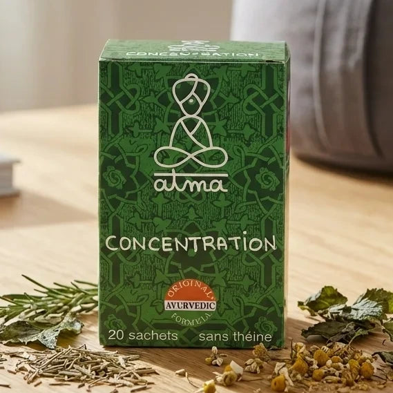 Infusion Bouddhi Concentration 20 sachets Atma sur bureau avec tasse de thé et herbes séchées