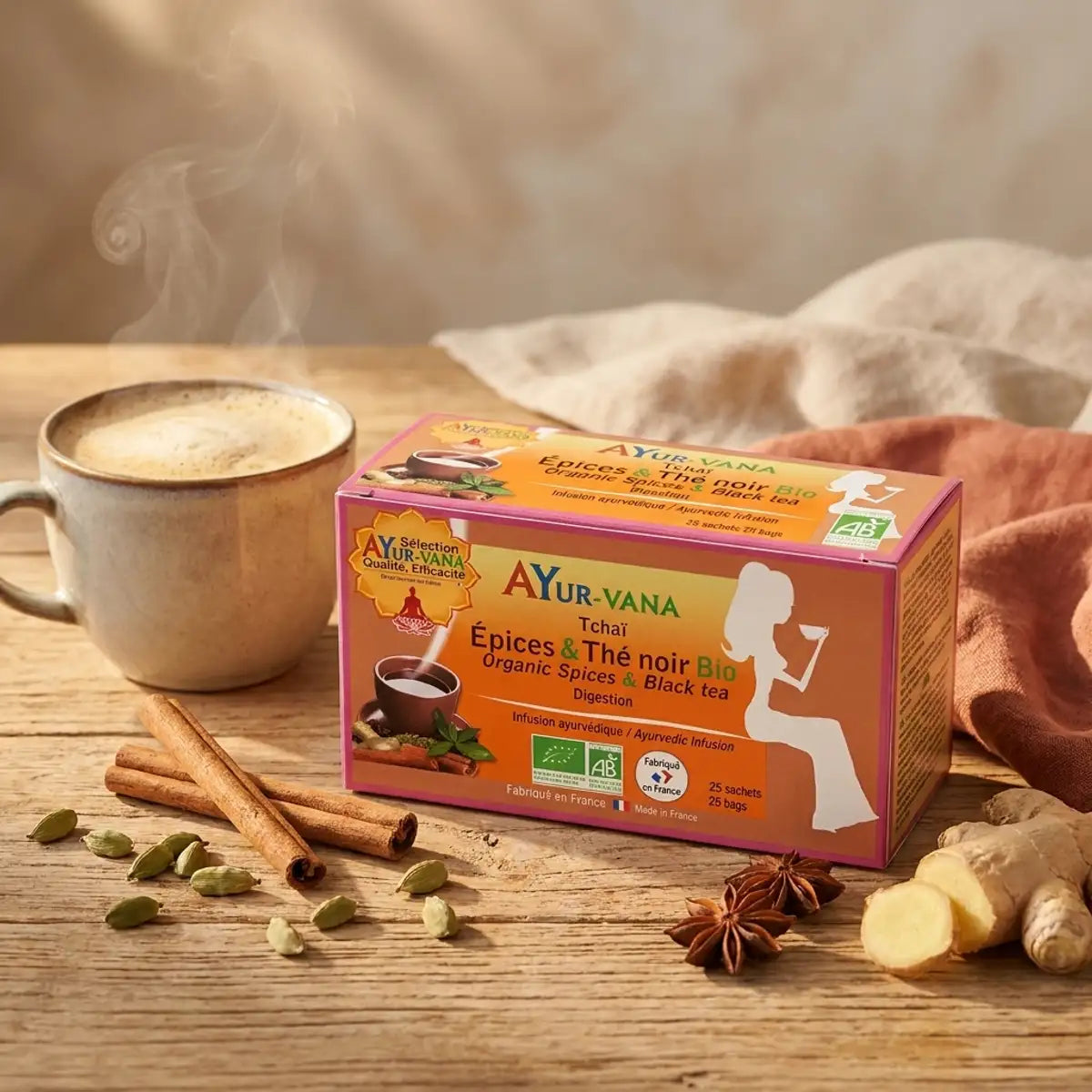 Boîte Tchaï épices & thé noir bio AyurVana entourée de cannelle, cardamome et gingembre frais