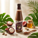 Bouteille Jus de Mangoustan Bio SFB 500ml entourée de fruits frais et feuilles tropicales