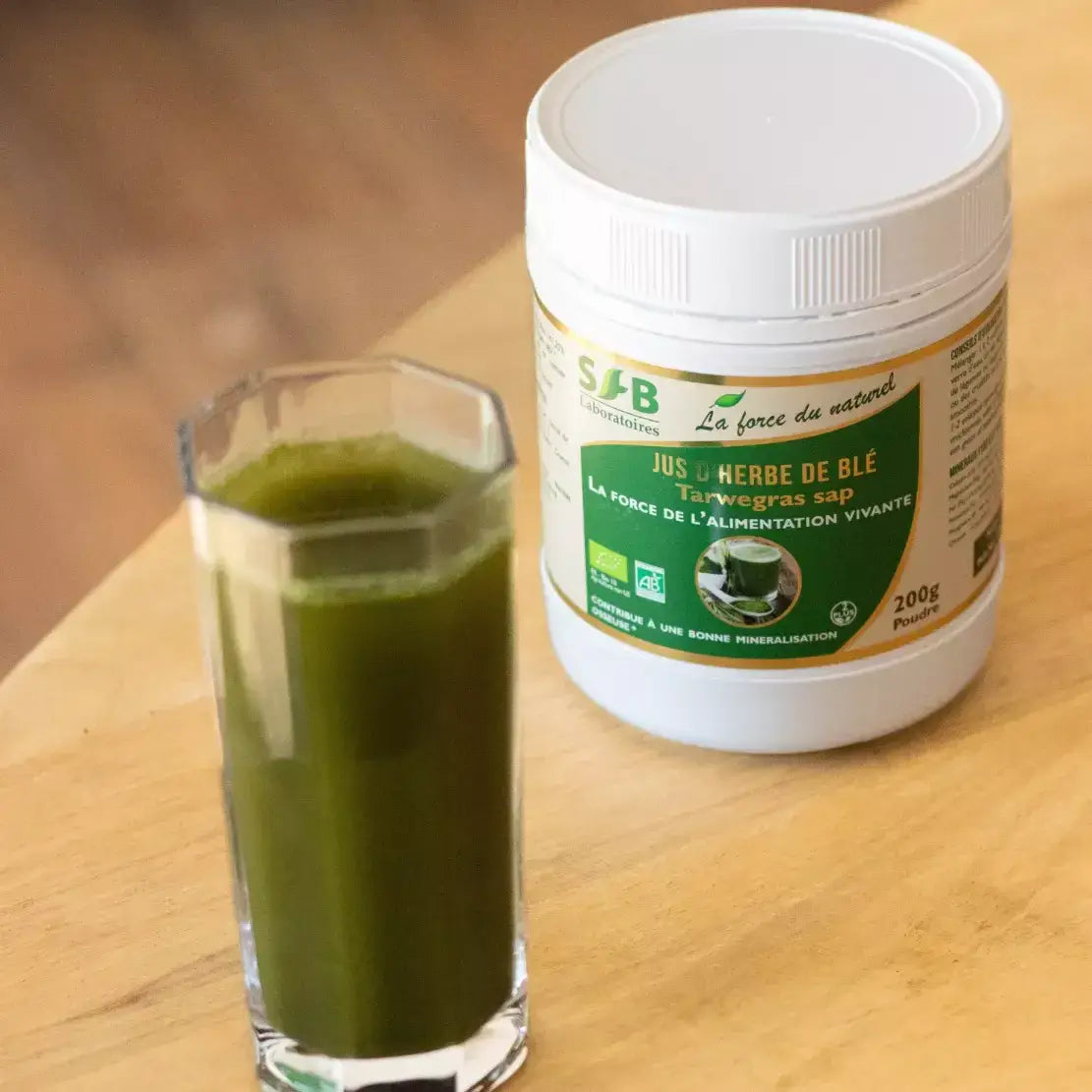 Un pot de Jus d'herbe de blé bio avec un verre à côté