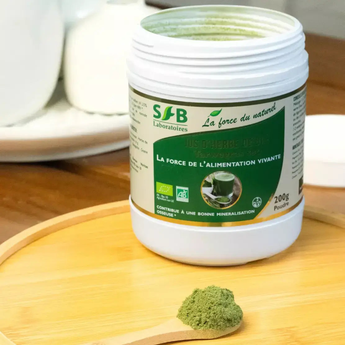 Un pot de Jus d'herbe de blé bio ouvert et posé sur une table en bois