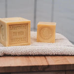 Cube Savon de Marseille 500g La Corvette 72% huiles végétales posé une serviette de toilette.