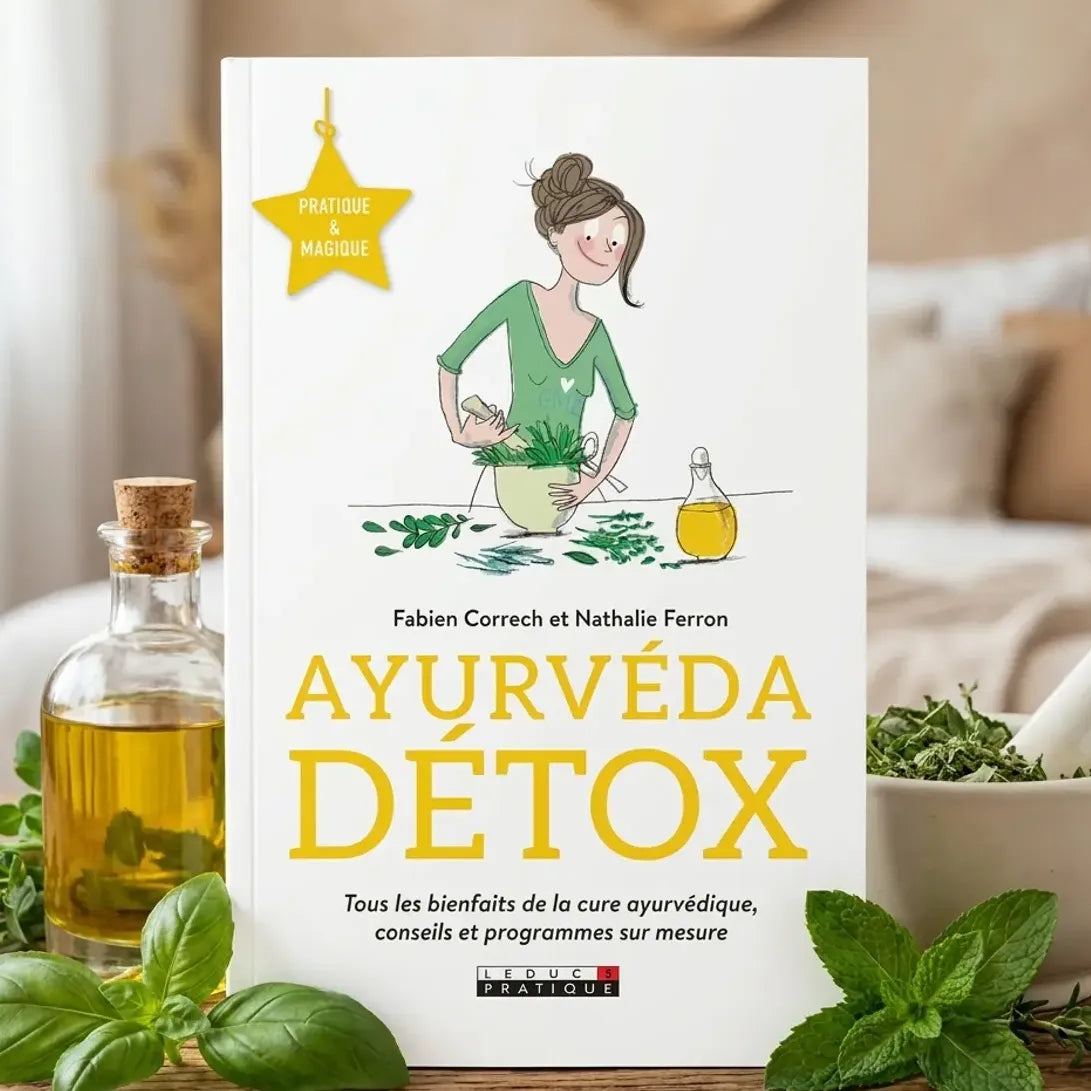 Livre Ayurvéda Détox avec herbes fraîches et huile dorée sur fond wellness