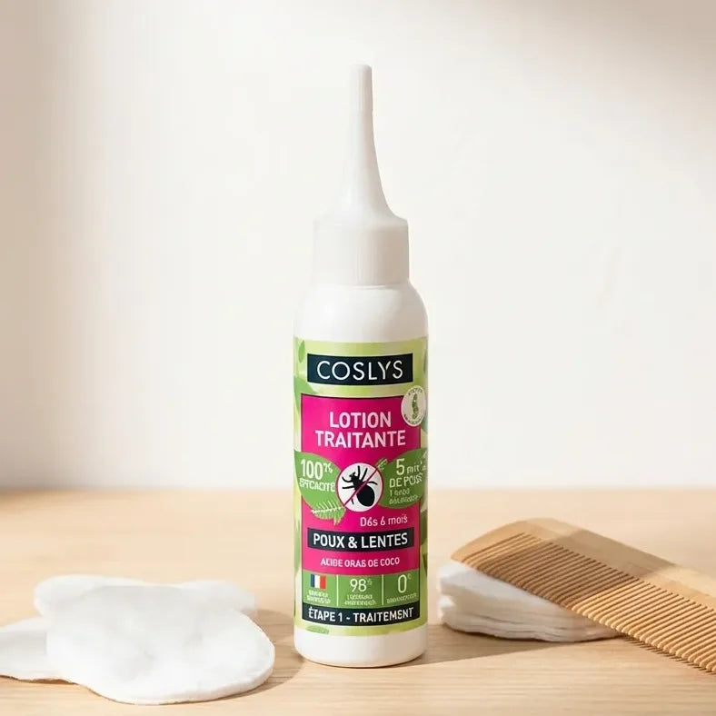 Lotion traitante poux Bio Coslys 100ml avec peigne et cotons sur surface bois
