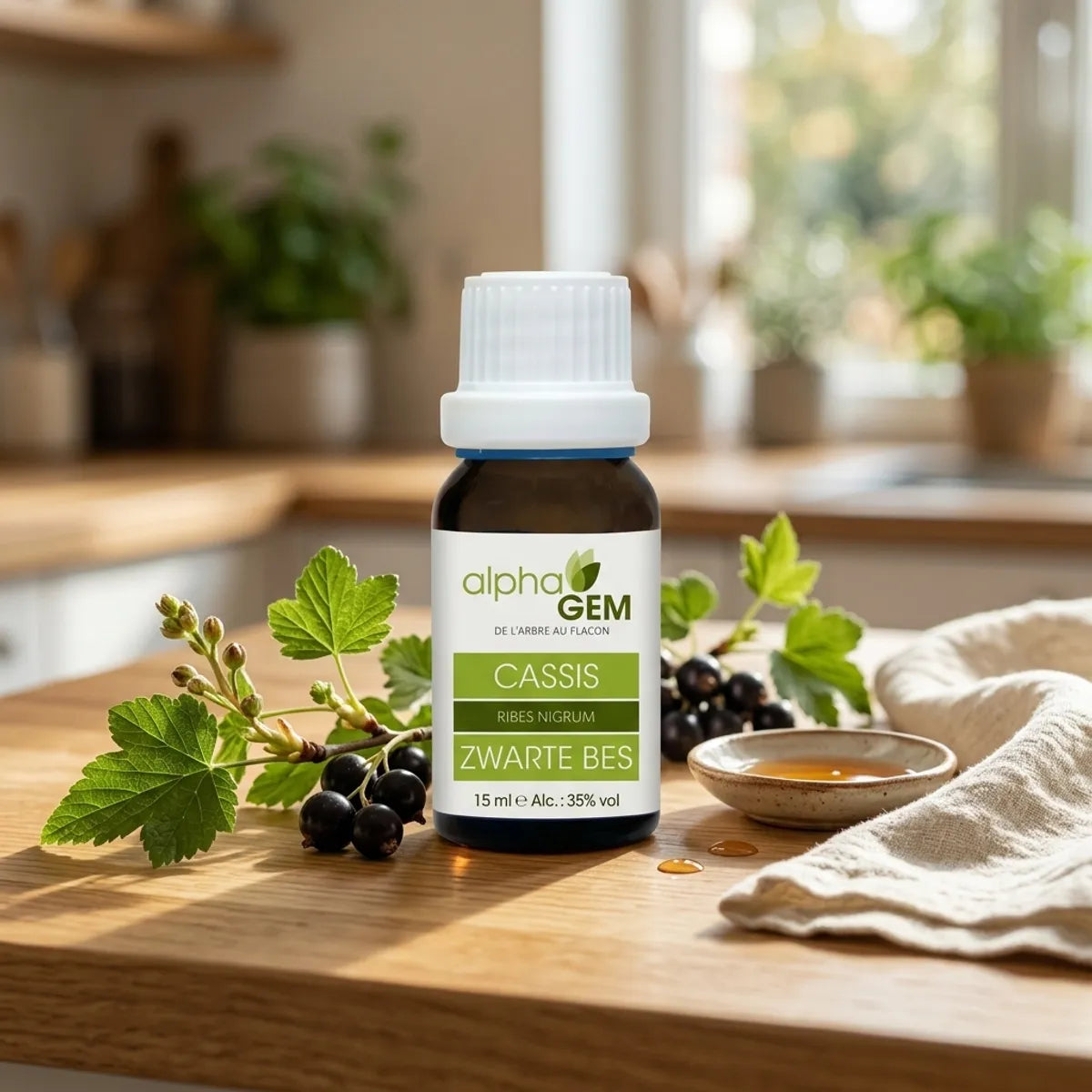 Flacon compte-gouttes en verre ambré de macérat de bourgeons de cassis bio 15 ml Alphagem, posé sur un plan de travail en bois avec branches de cassis.