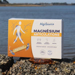 Une boite de 20 ampoules de Magnésium Articulations de la marque Algosource posée sur des rochers devant la mer