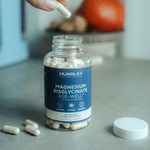 Une boîte de 90 géllules de magnésium ouverte avec des gélules posées