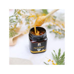 Zoom sur un pot de miel de Manuka IAA 15+ de 250 g de la marque Comptoirs et compagnies, ouvert et en train d'être prélevé