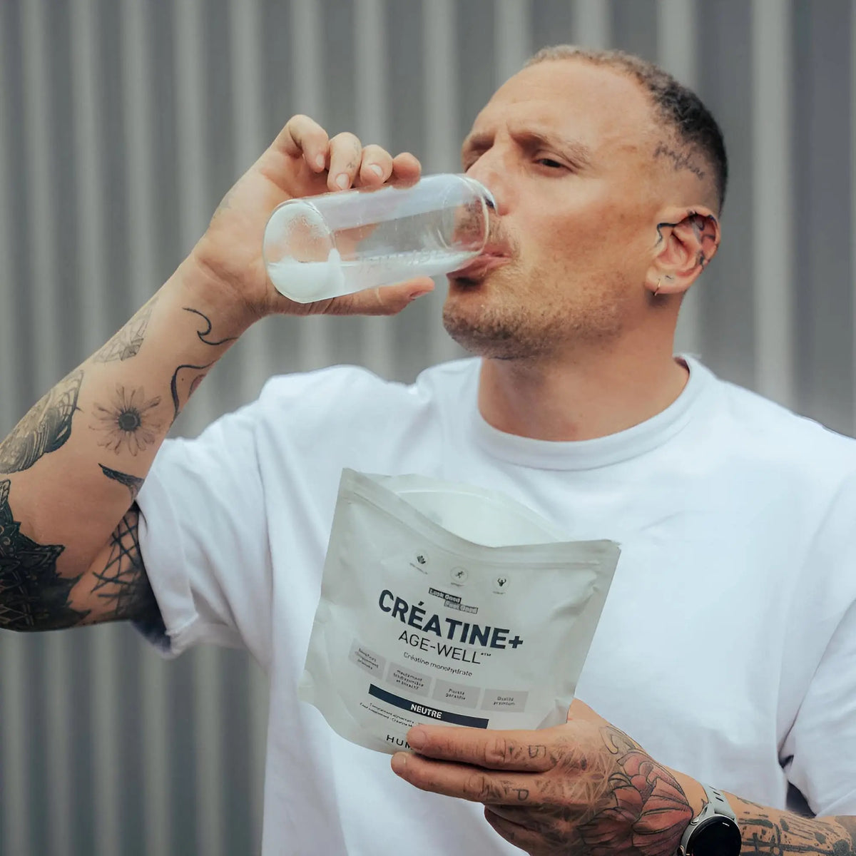 Un homme buvant un verre d'eau contenant de la créatine âge well humble.