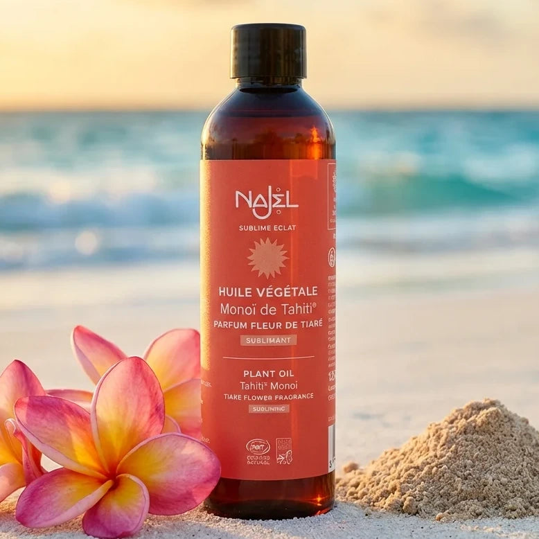 Flacon Monoï de Tahiti Najel 125ml sur plage avec fleurs tiare roses