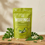 Poudre de Moringa Iswari 125g avec feuilles fraîches sur surface bois naturelle