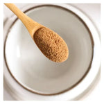 Une cuillère en bois remplie de Morning latte original chaï bio nüMorning