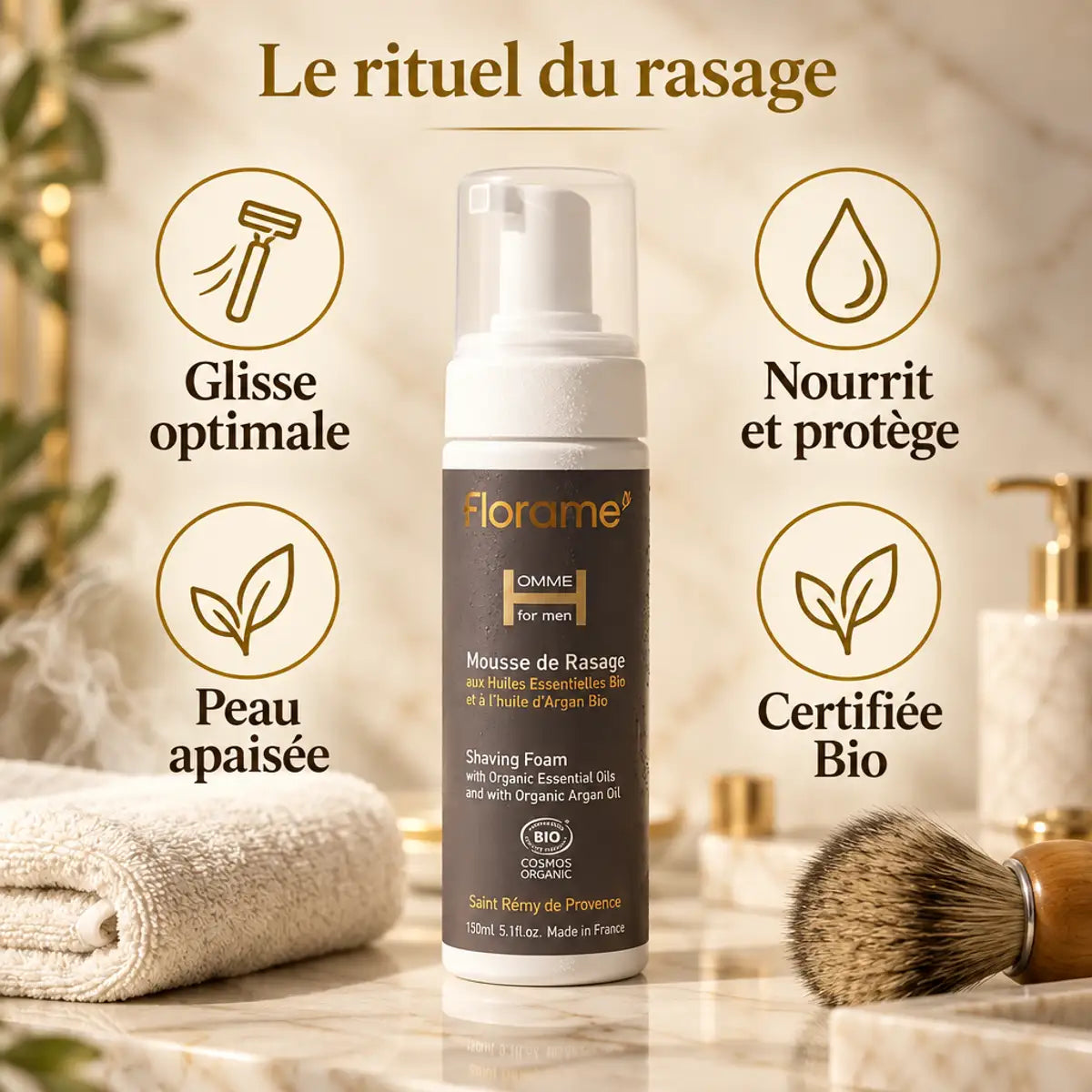 Mousse de rasage bio Florame 150 ml avec flacon pompe, posée sur un plan de marbre aux côtés d'une serviette et d'un blaireau en bois