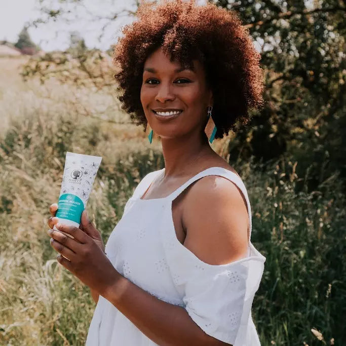 Femme qui tient le Shampoing Première mousse Noire o Naturel
