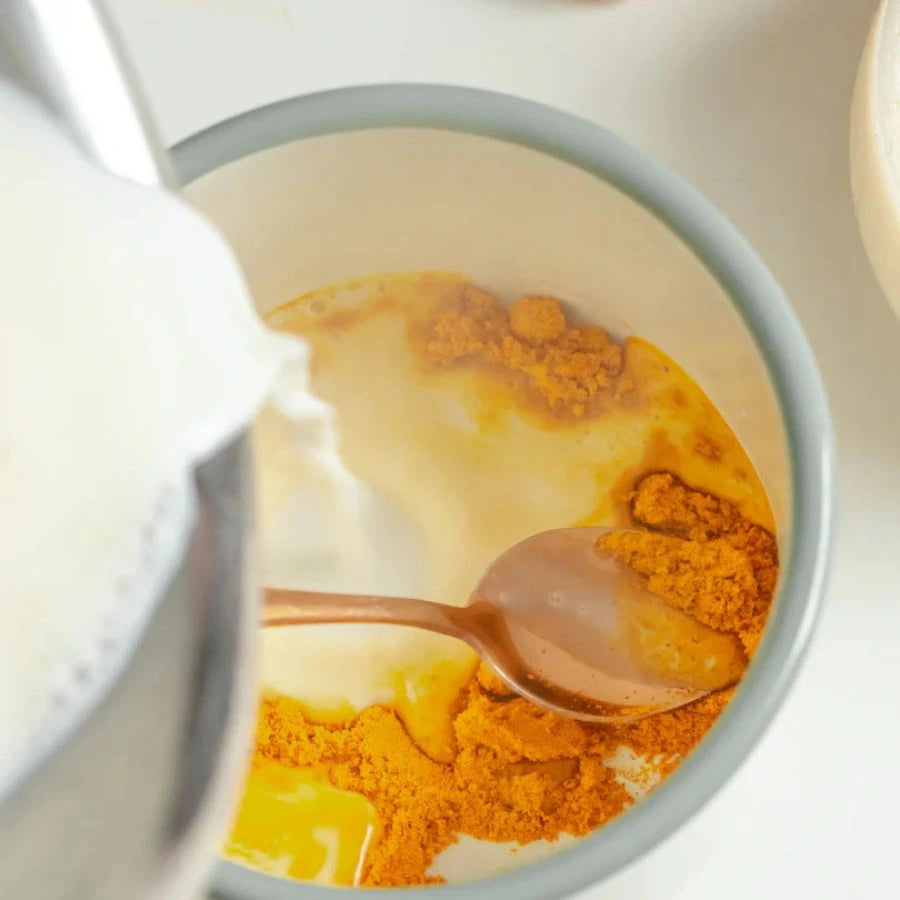 Du lait versé dans une tasse de magic golden latte nümorning