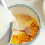 Du lait versé dans une tasse de magic golden latte nümorning