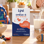 Boîte Lysi Oméga-3 pour enfants sur un plan de travail en bois, parent versant du lait dans une cuisine lumineuse