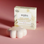 Pain lavant dermatologique à l'amande douce de la marque Endro accompagné de l'emballage sur un fond rose.