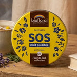 Pastilles Biofloral SOS Nuit Paisible sur table de nuit avec tisane et lavande