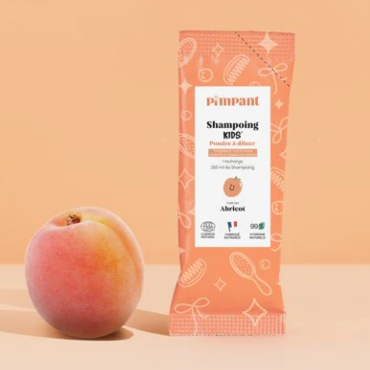 Un Shampoing kids à diluer Pimpant 30 g posé à côté d'un abricot