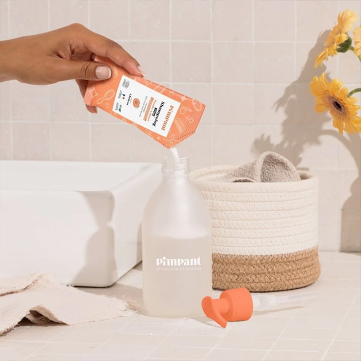 Photo d'une personne personne versant un stick de Shampoing kids à diluer Pimpant de 30 g dans une bouteille rechargeable