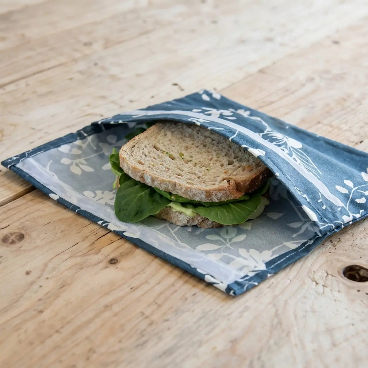 Pochette conservation coton enduit Angie Be Green ouverte avec sandwich et légumes frais sur bois