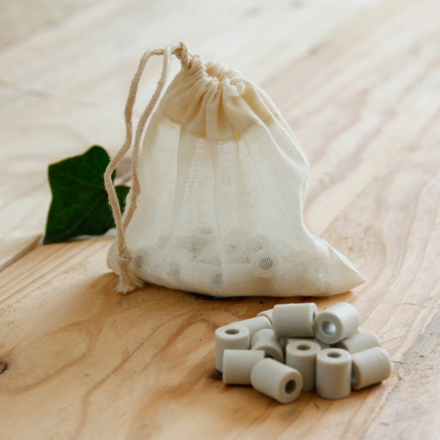 pochon avec des perles de céramiques posés sur une table en bois