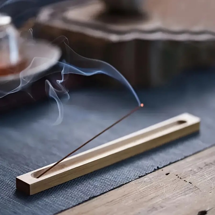 Un porte encens en bambou avec un encens en combustion et de la fumée
