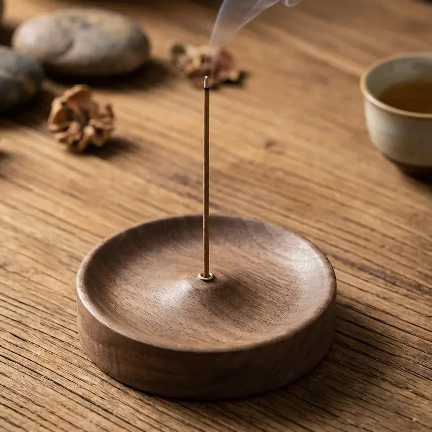 Porte-encens en bois rustique avec insert en laiton sur table en bois clair