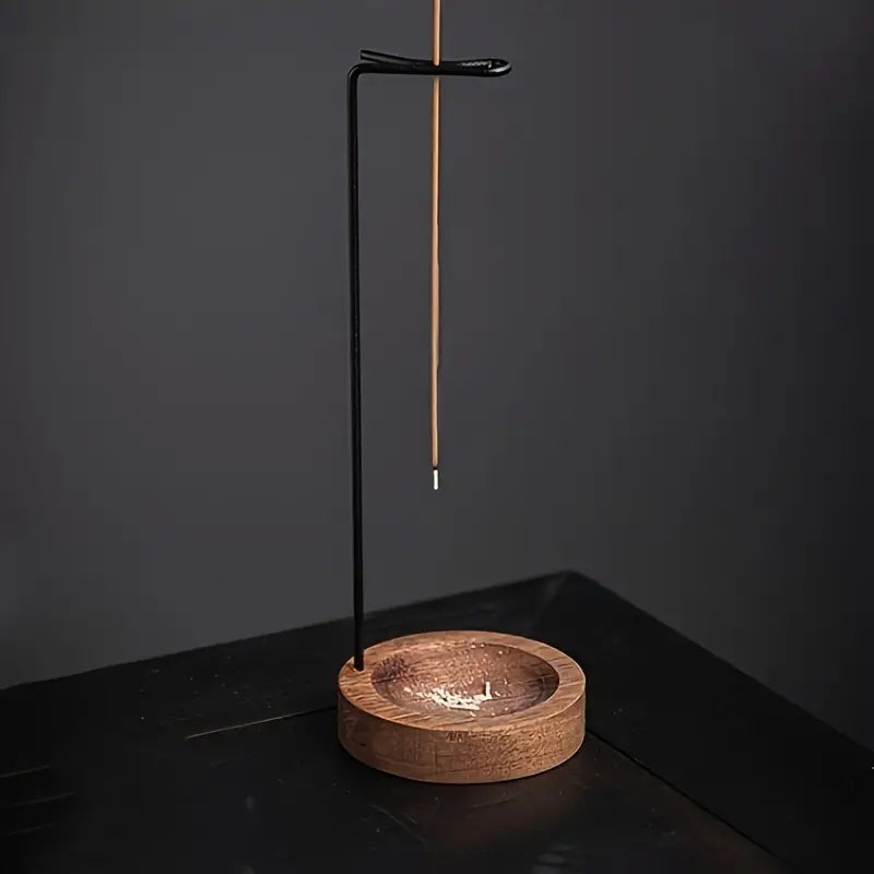 Un Porte-encens suspendu en bois posé sur une table noire