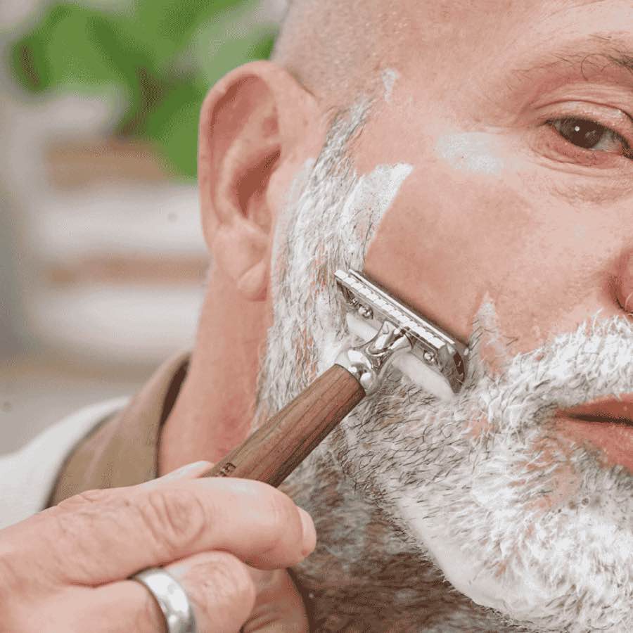 Un homme se rasant la barbe avec le rasoir lamazuna