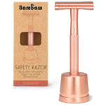 Un. rasoir de sûreté en métal avec socle, couleur or rose, de la marque Bambaw