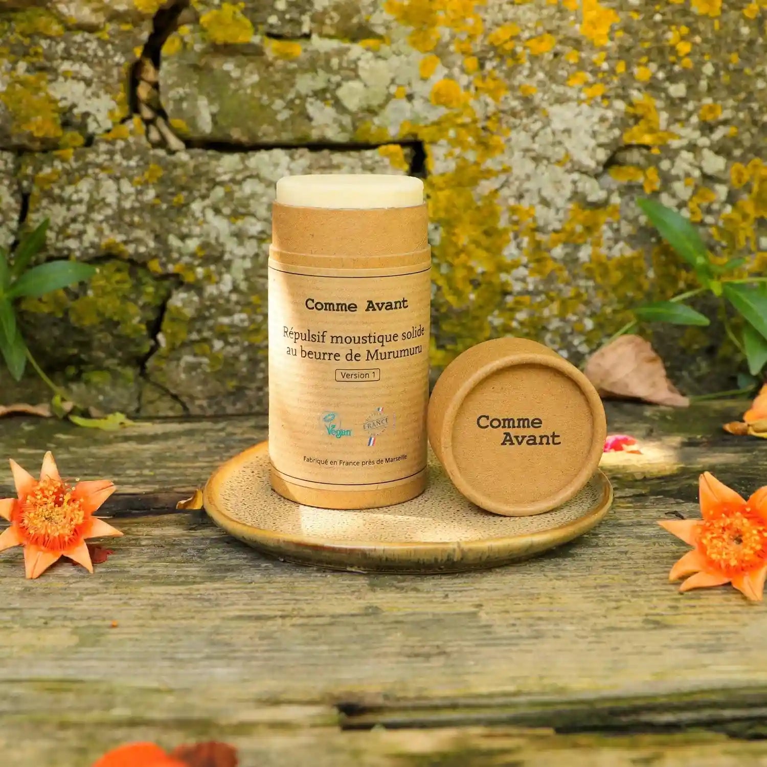 Packshot d'Un Répulsif Moustique Solide au Beurre de Murumuru Comme Avant sur une jolie coupelle en marbre devant un mur de pierre