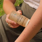 Photo d'une femme en train d'appliquer sur son bras du Répulsif Moustique Solide au Beurre de Murumuru Comme Avant