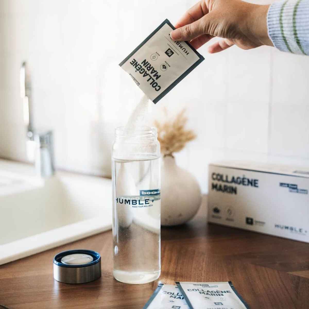 Un sachet de collagene marin 5g versé dans une gourde d'eau humble+.
