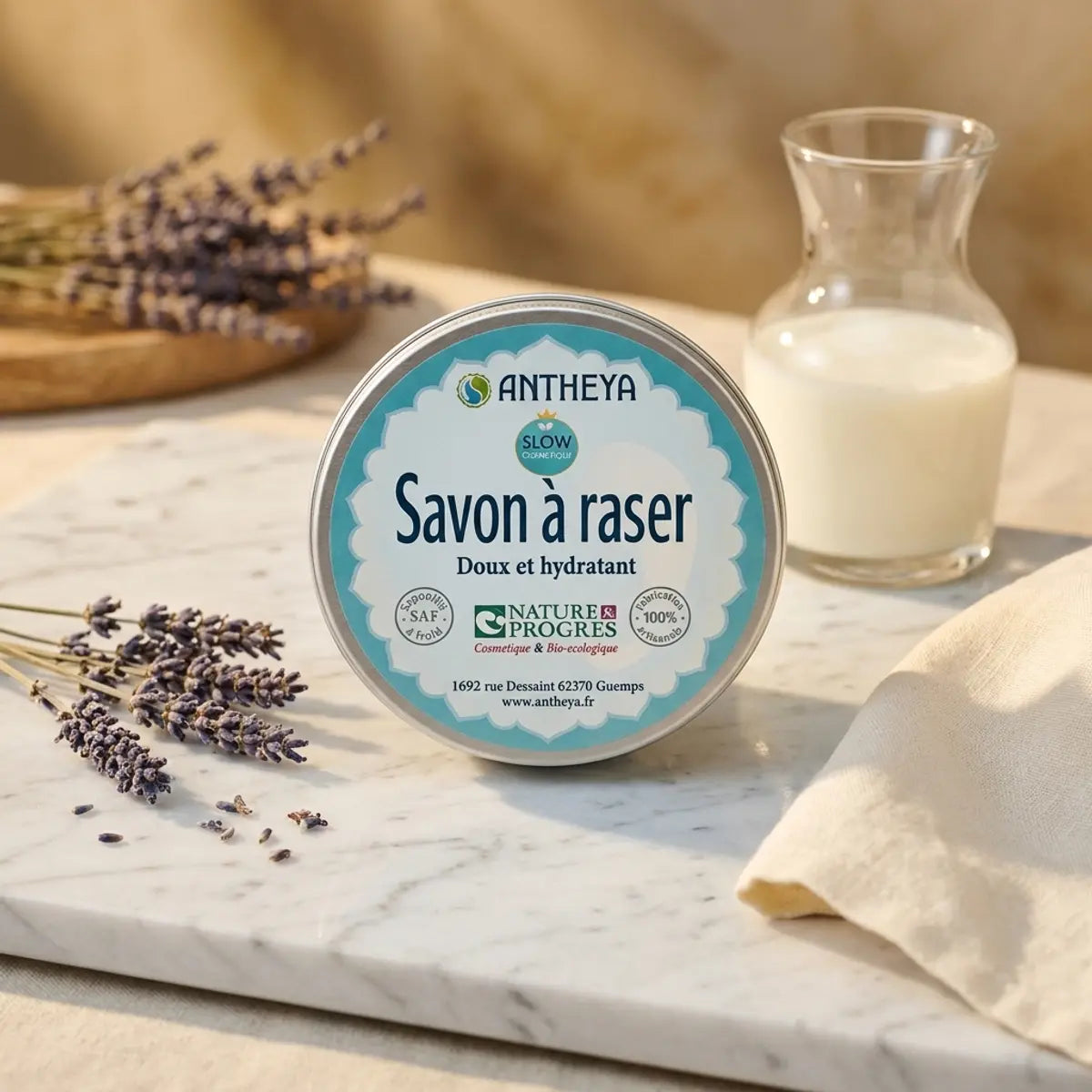 Savon à raser Antheya lait de chèvre bio 90g en boîte turquoise sur surface marbre avec lavande