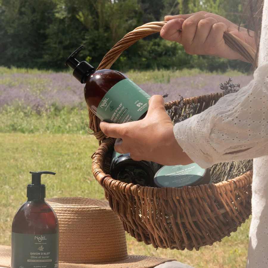 Savon d'Alep liquide Najel 500ml en extérieur dans un panier en osier 