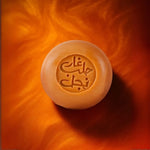 Un savon d'alep à l'huile de nigelle de la marque Najel sur un fond orangé