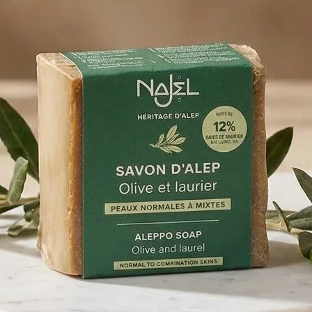 Savon d'Alep Najel 12% huile de baies de laurier 180g sur surface marbre avec branches d'olivier
