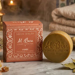 Savon d'Alep parfumé Ambre Al Bara dans son emballage sur marbre avec bougies et ambiance spa