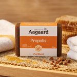 Savon Propolis Aagaard 100g sur surface bois avec emballage et miel, rituel beauté naturel