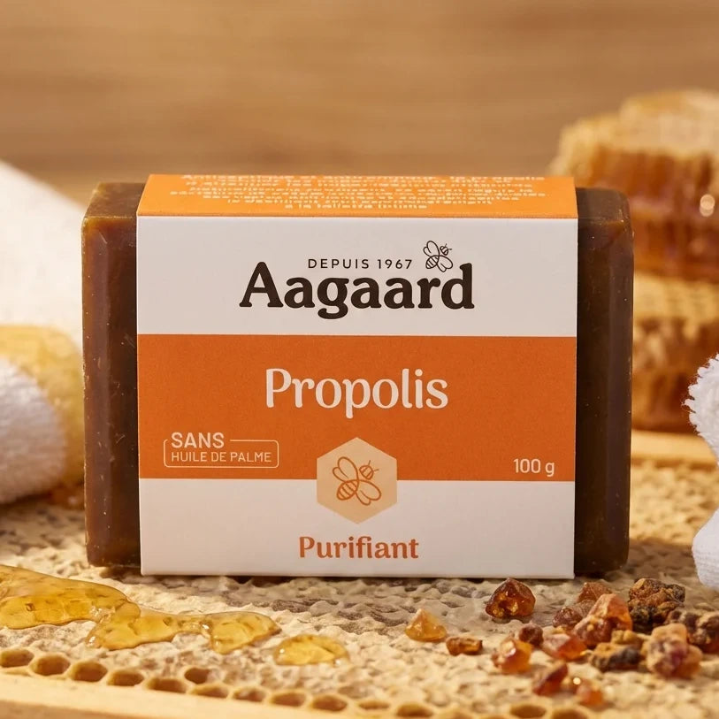 Savon Propolis Aagaard 100g sur surface bois avec emballage et miel, rituel beauté naturel