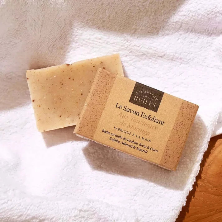 Deux savons exfoliants aux tourteaux de moringa de la marque Comptoir des huiles posés sur une serviette blanche