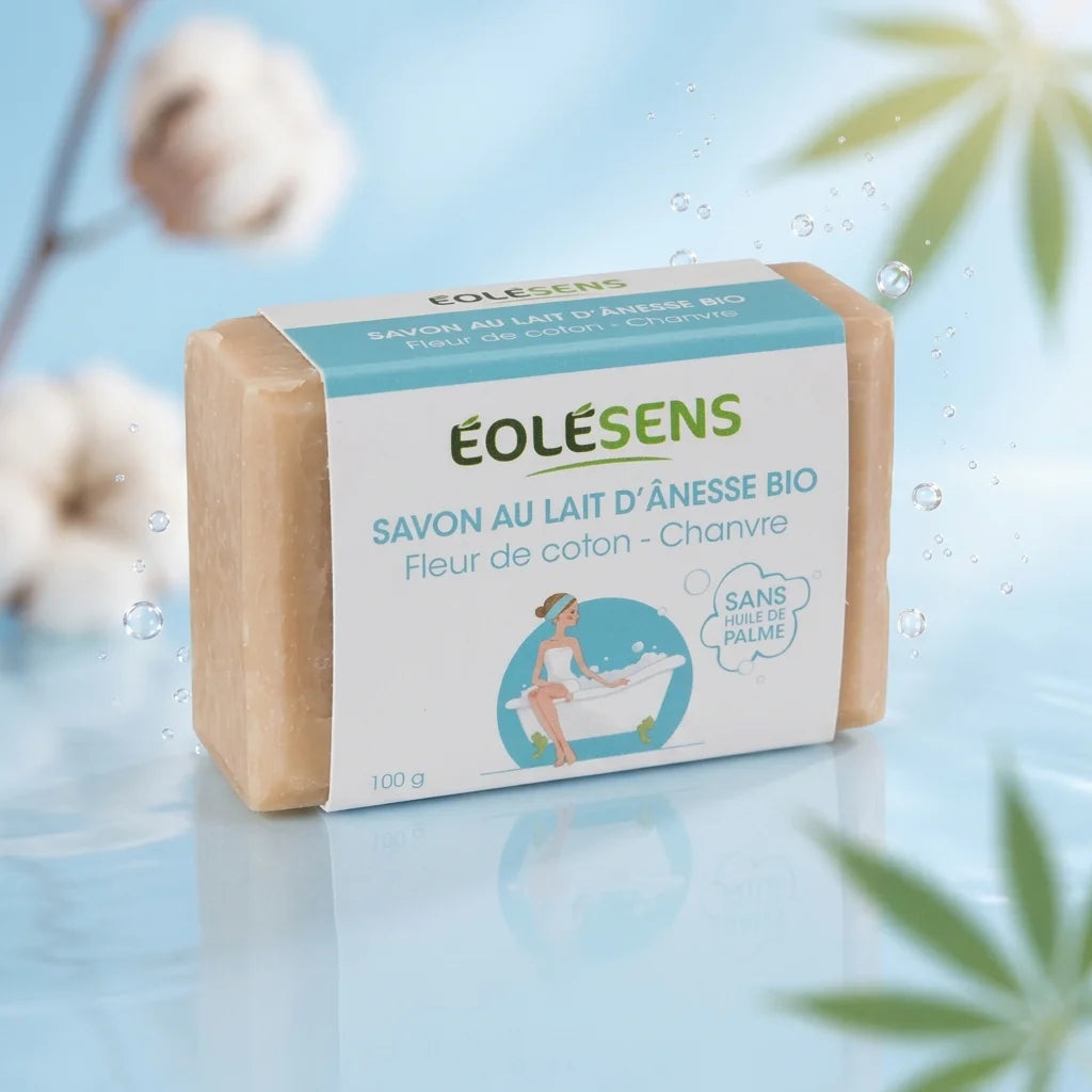 Savon lait d'ânesse bio et fleurs de coton Eolesens 100g sur fond bleu avec gouttes d'eau