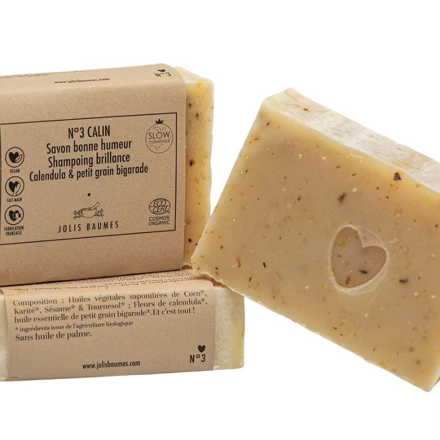 Savon bonne humeur, shampoing brillance, calendula & petit grain bigarade de la marque Jolis Baumes posé sur son packaging