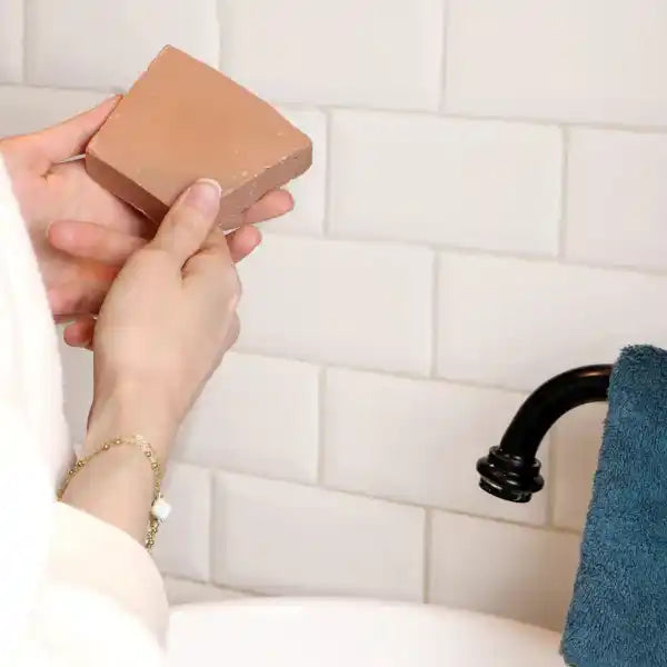 Un savon pour peaux sèches de 100 g de la marque Comme Avant tenu en main