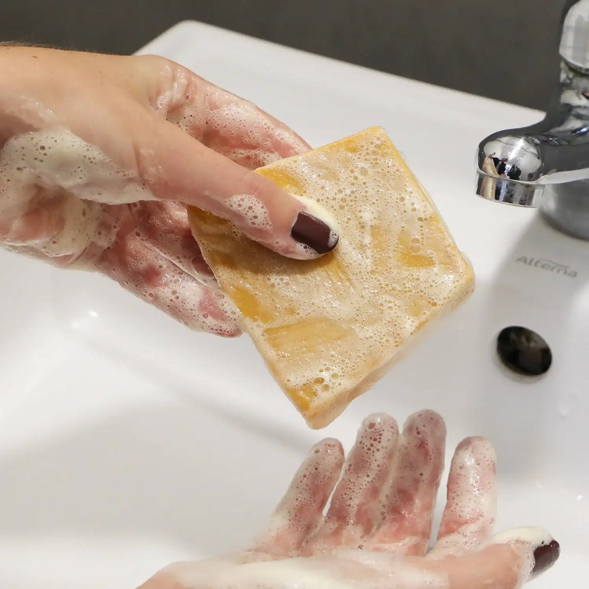 Zoom sur un savon pour peaux normales au beurre de karité de 100 g de la marque Comme Avant en train d'être utilisé