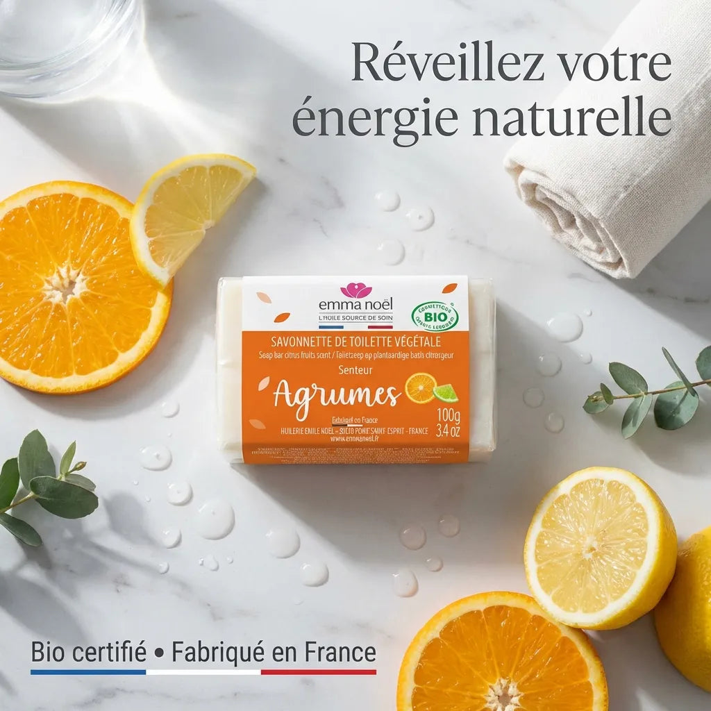 Savonnette Agrumes Bio Emma Noël 100g sur marbre avec citrons et gouttes d'eau