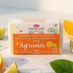 Savonnette Agrumes Bio Emma Noël 100g sur marbre blanc avec agrumes frais et feuilles vertes
